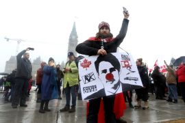 A protester holds a sign denouncing Prime Minister Justin Trudeau outside Parliament Hill in Ottawa