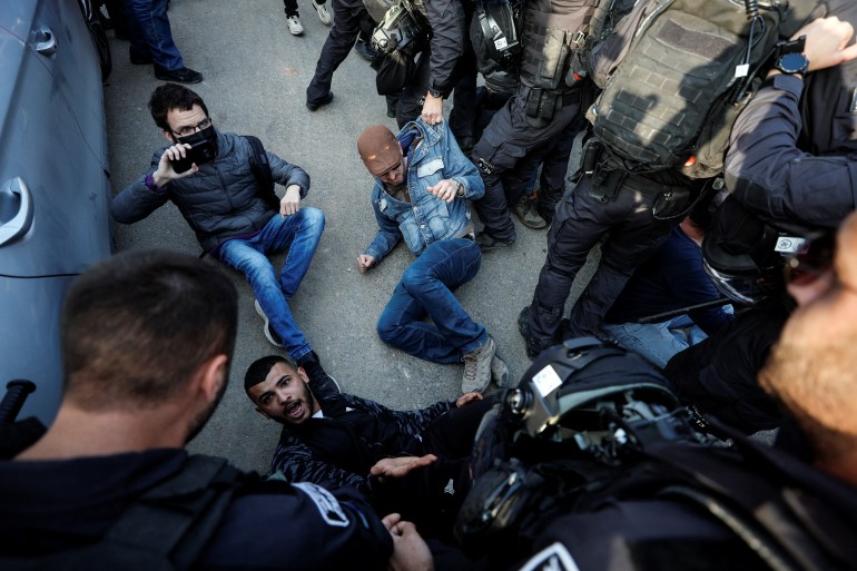 Protesters lie on the ground in front of Israeli security forces during a demonstration in the Sheikh Jarrah neighbourhood of East Jerusalem