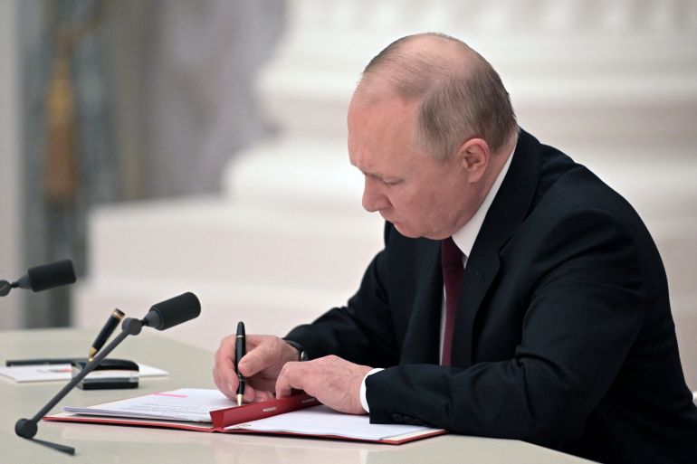 Russian President Vladimir Putin signs documents