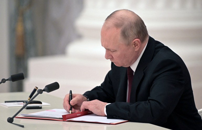 Russian President Vladimir Putin signs documents