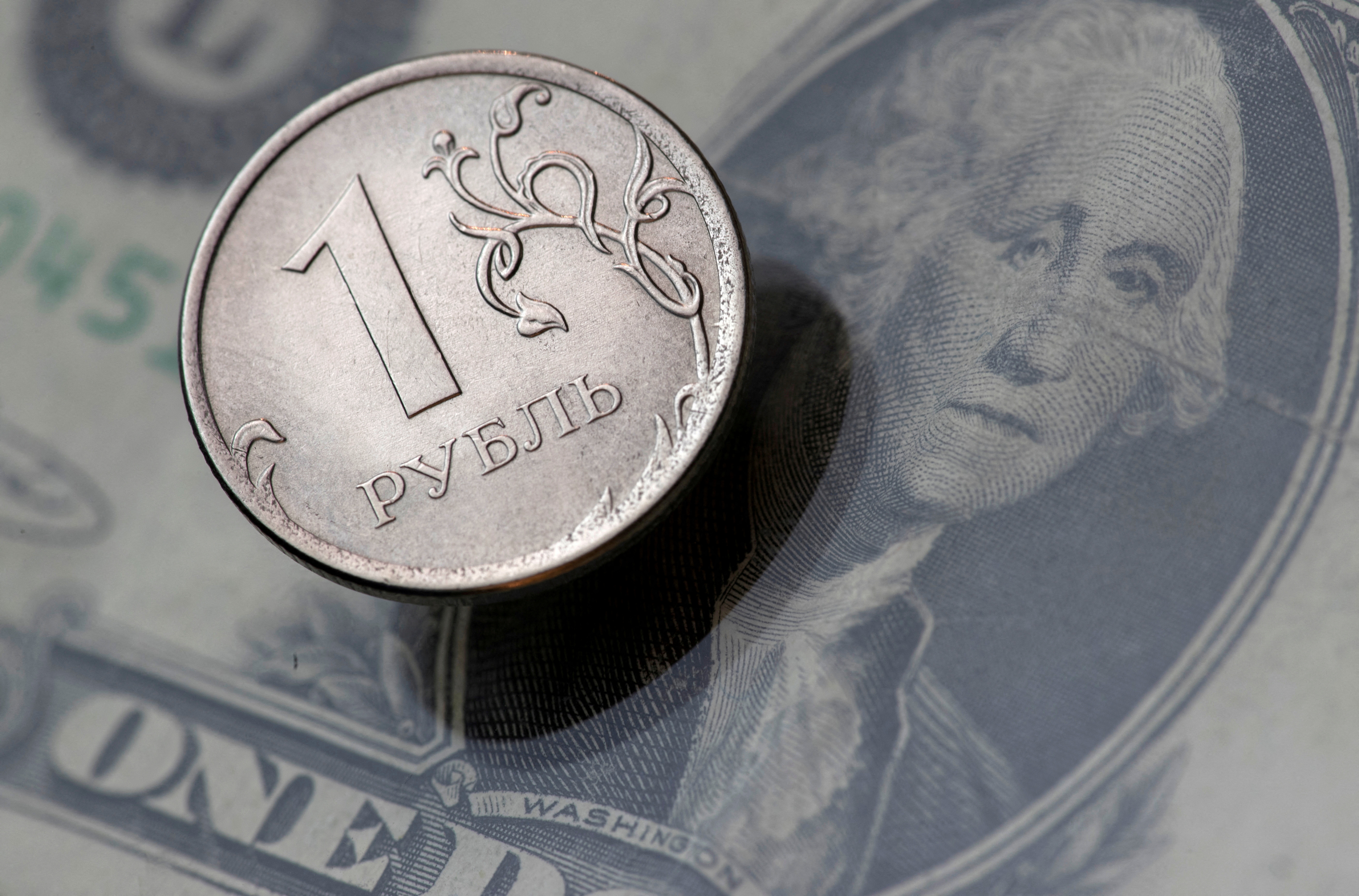 Una vista mostra una moneta in rublo russo e una banconota in dollari USA