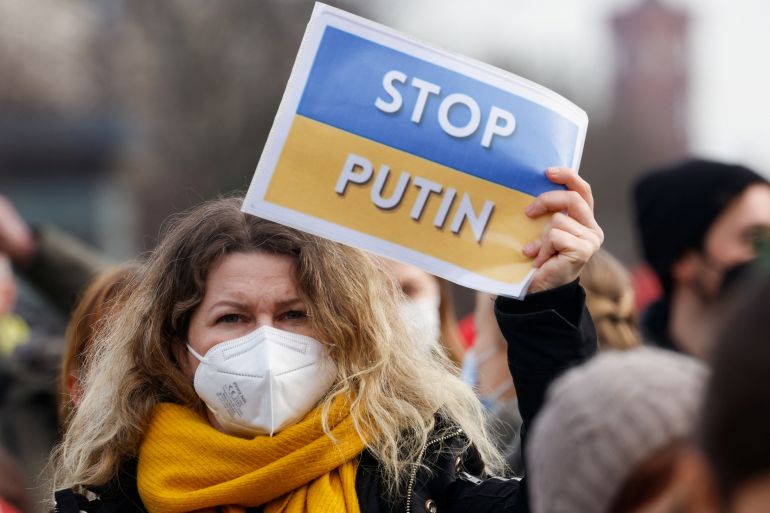 A demonstrator holds a stop Putin sign