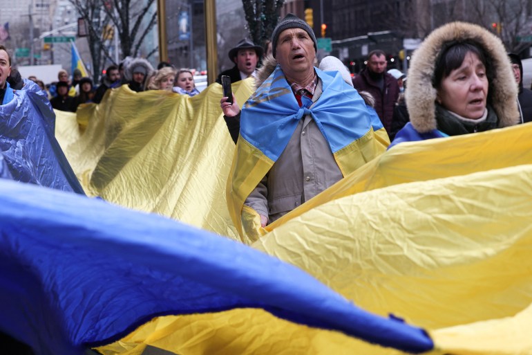 Protesters wrapped in Ukrainian flags
