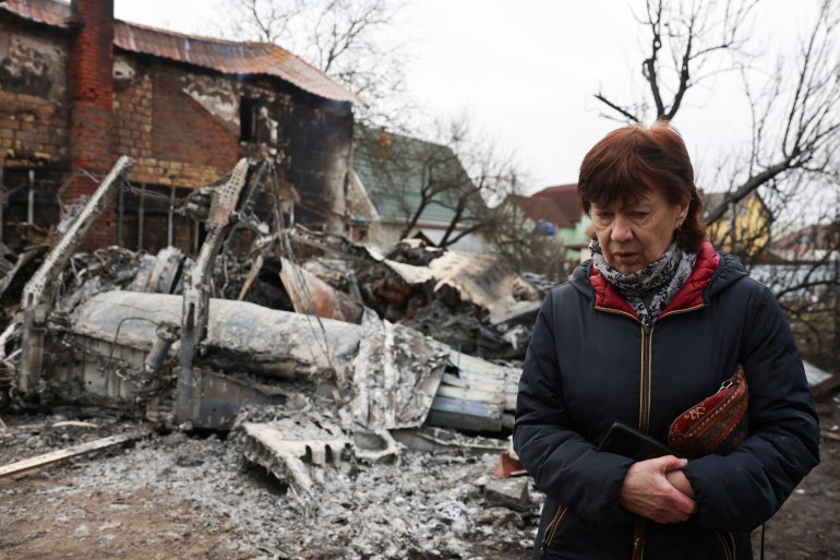 Una persona en Kiev camina entre los restos de un avión no identificado que se estrelló contra una casa en una zona residencial.