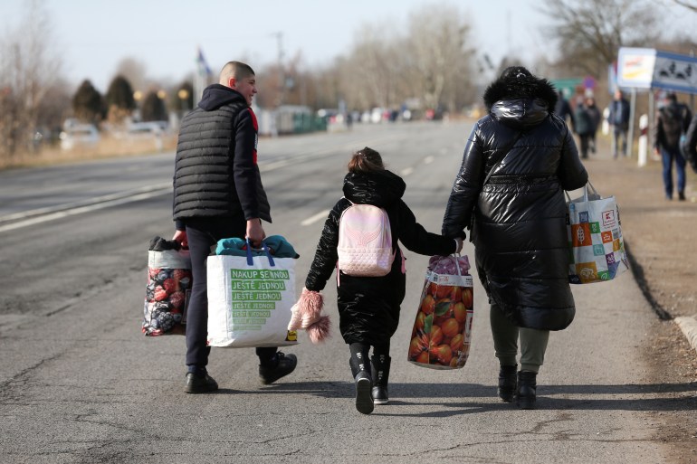 People walk as they flee from Ukraine to Hungary, after Russia launched a massive military operation against Ukraine, at a border crossing in Beregsurany, Hungary, February 25, 2022.