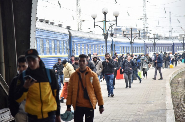 Passengers, including evacuees from the cities of Sumy and Kyiv, walk along the platform of a railway station upon their arrival in Lviv, Ukraine 
