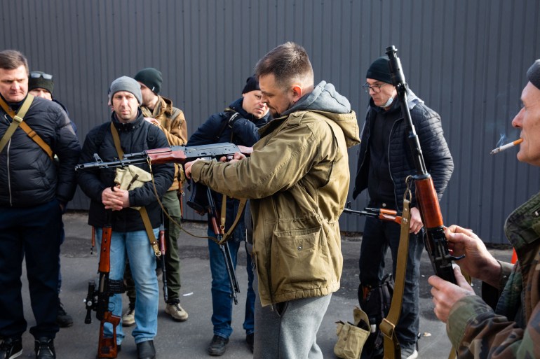 Members of the Territorial Defence Forces of Ukraine are seen receiving weapons to defend the city of Kyiv