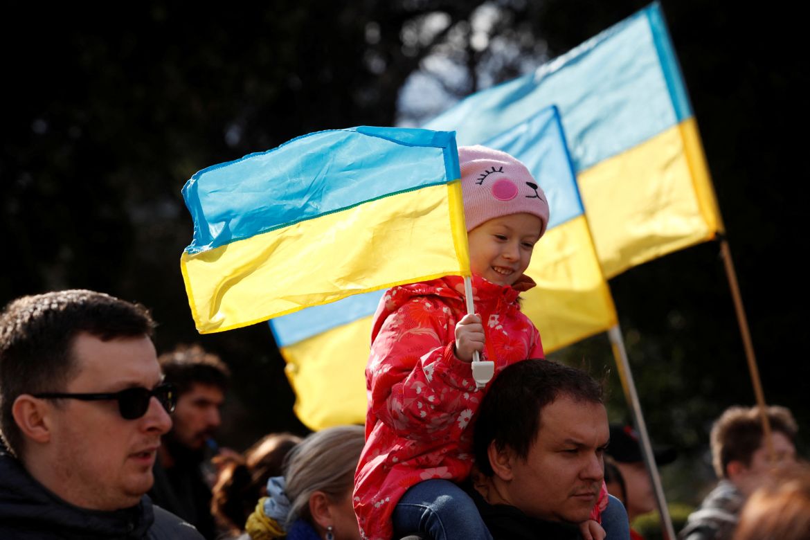 A girl holds a Ukrainian flag during an anti-war protest march, after Russia launched a massive military operation against Ukraine, in Podgorica