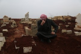 Fatima’s father Mohamad Al Hassan sits by her grave near Laith displacement camp where they lived for seven years
