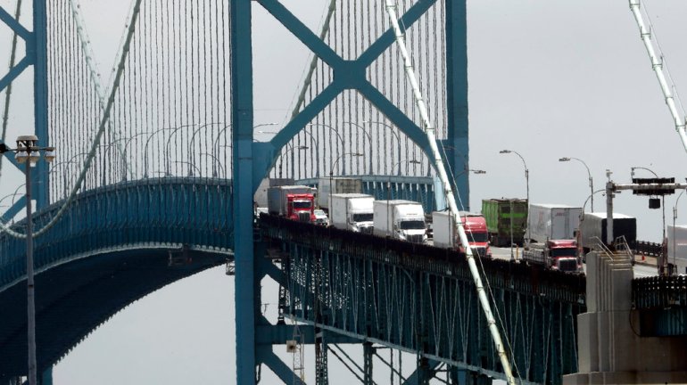 trucks cross the Ambassador Bridge from Windsor, Ontario into Detroit. 