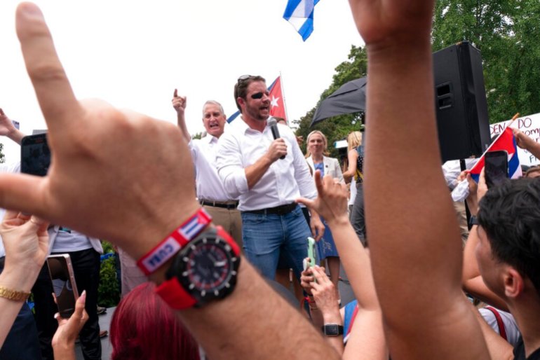 Rep.  Mario Diaz-Balart, R-Fla., Left, points to the crowd as Rep.  Dan Crenshaw, R-Texas, speaks during a protest by the Cuban government, Monday, July 26, 2021, at Lafayette Park near the White House.