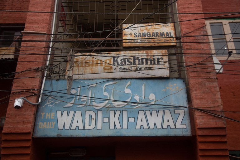 Billboards with names of newspapers stand at the entrance of a building at Press Enclave