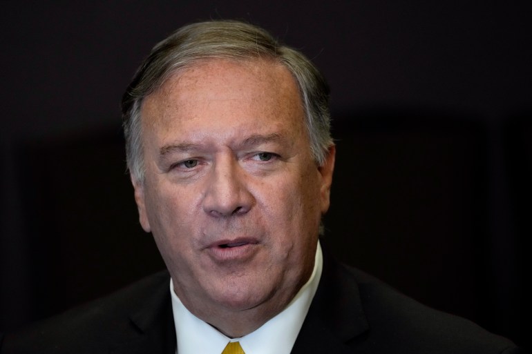 A portrait of former US Secretary of State Mike Pompeo in a dark suit and white shirt