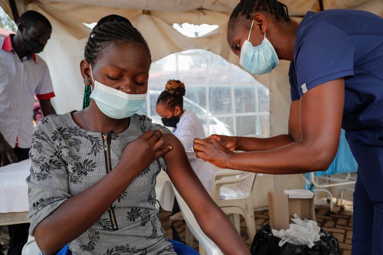 A nurse administers an AstraZeneca vaccination against COVID-19, at a district health center