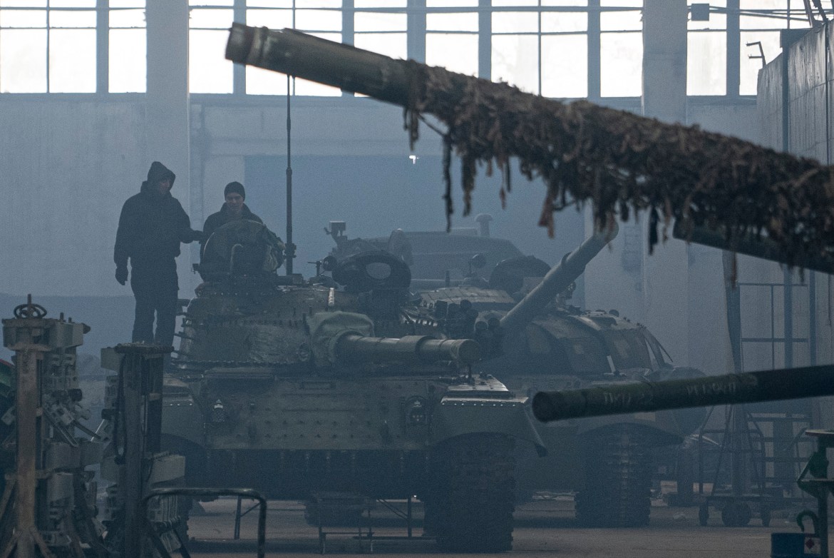 Workers stand atop a tank T-64 on Repair Tank Factory in Kharkiv,