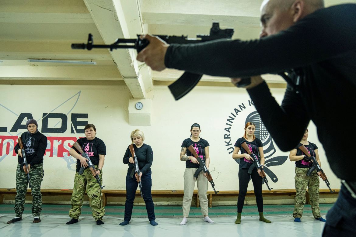 An instructor shows how to use weapons to a group of women during training in Kharkiv