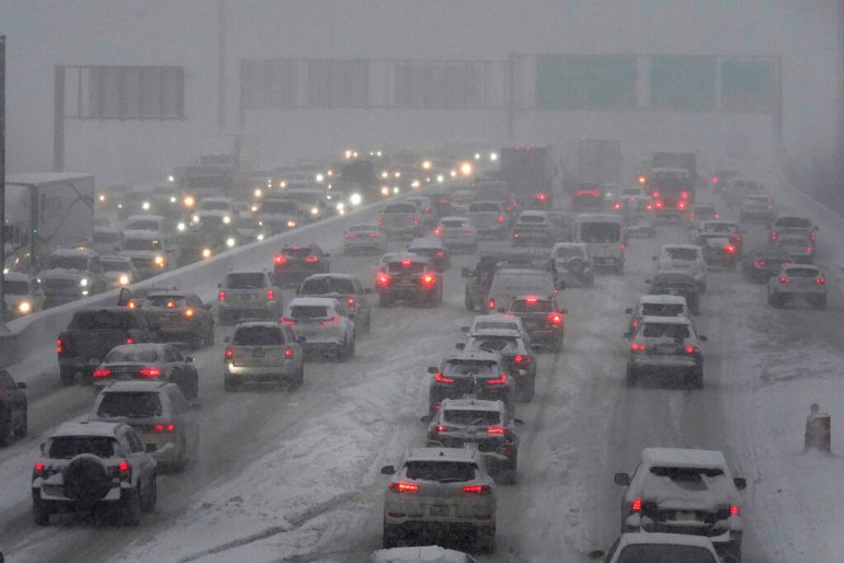 Motorists navigate the northbound, left, and southbound lanes of Interstate 90-40 during a snowy morning.