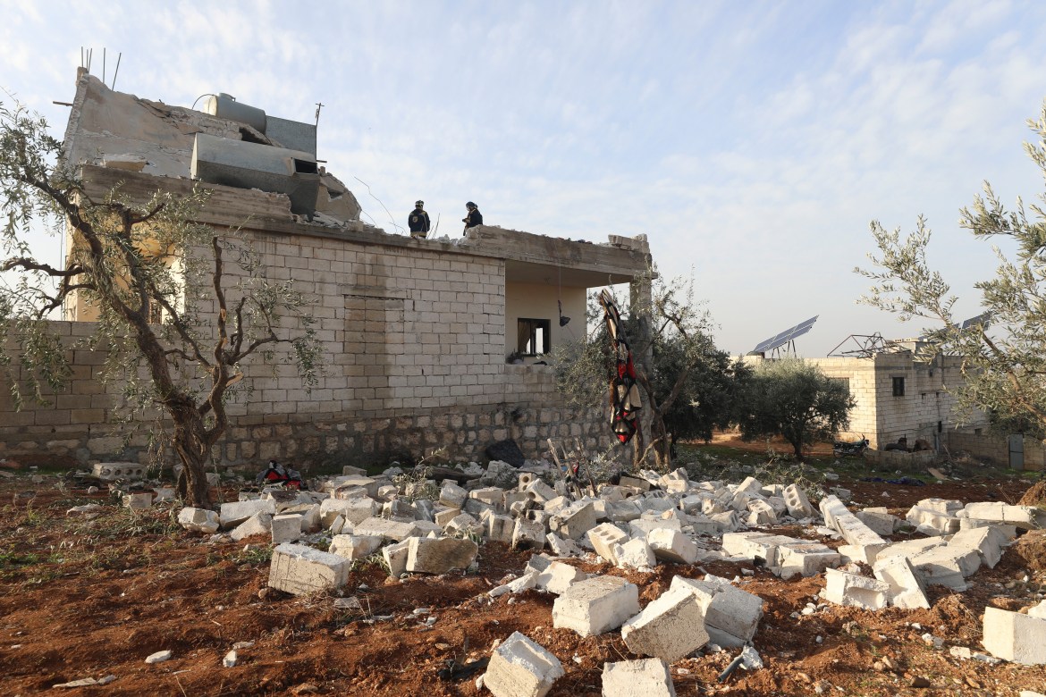 People check at a destroyed house after an operation by the U.S. military in the Syrian village of Atmeh