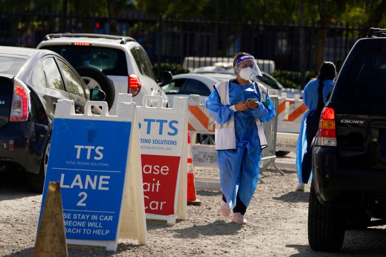 Workers wear protective equipment at a COVID-19 testing site in the Boyle Heights section of Los Angeles.