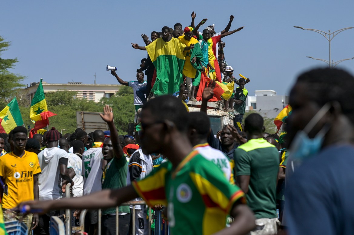 Senegalese football fans celebrate as they await the return of their national team in Dakar