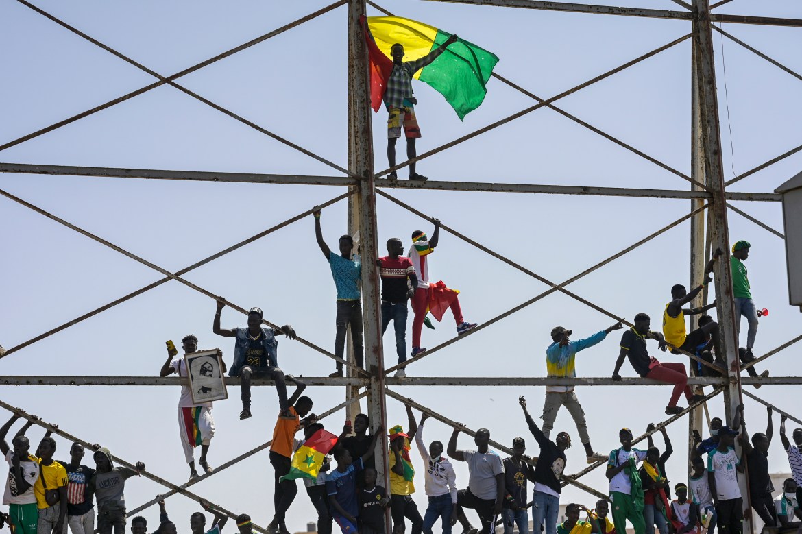 Senegalese soccer fans celebrate as they await the return of their national team