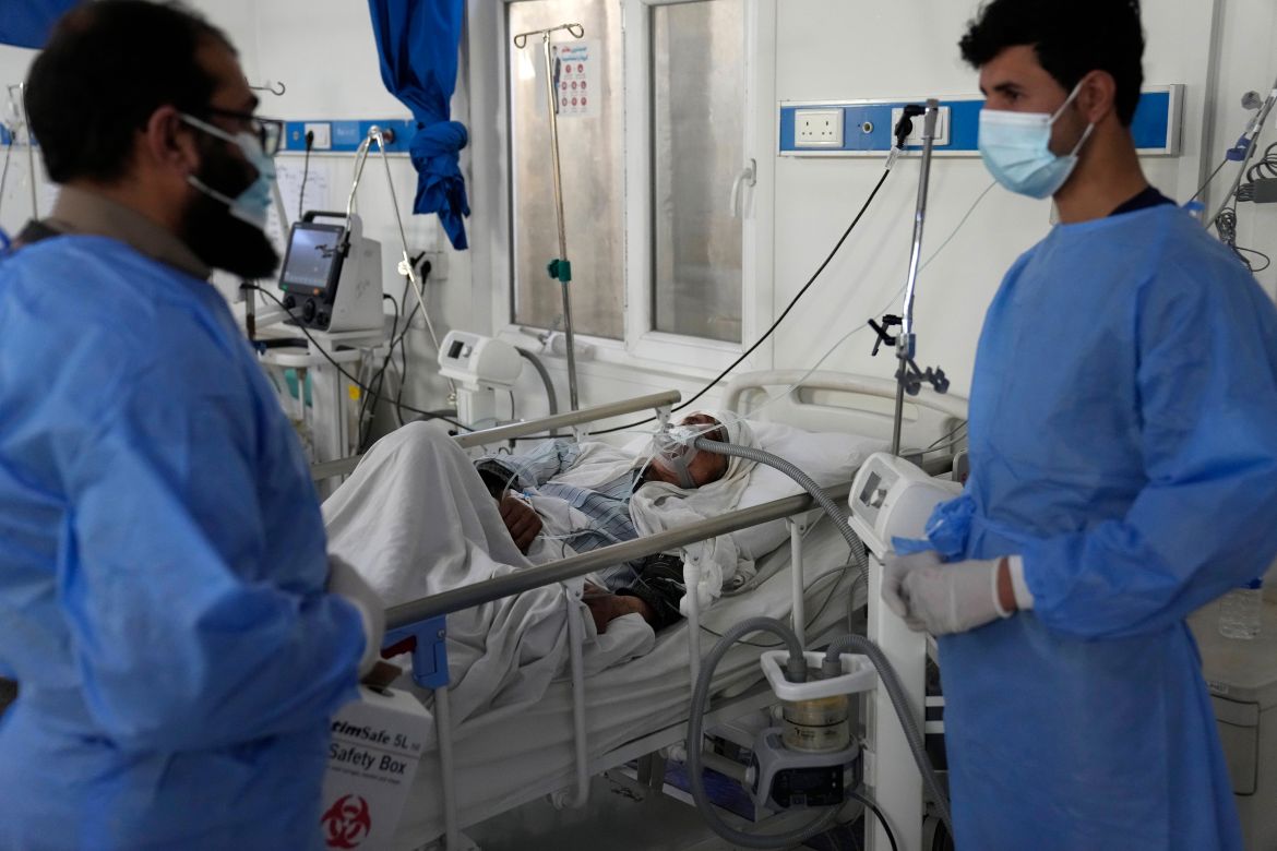 Two doctors talk as an Afghan patient with COVID-19