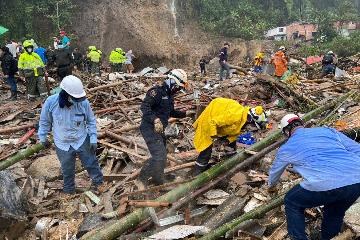Rescue workers search for survivors after a rain-weakened hillside collapsed on people's homes in Pereira