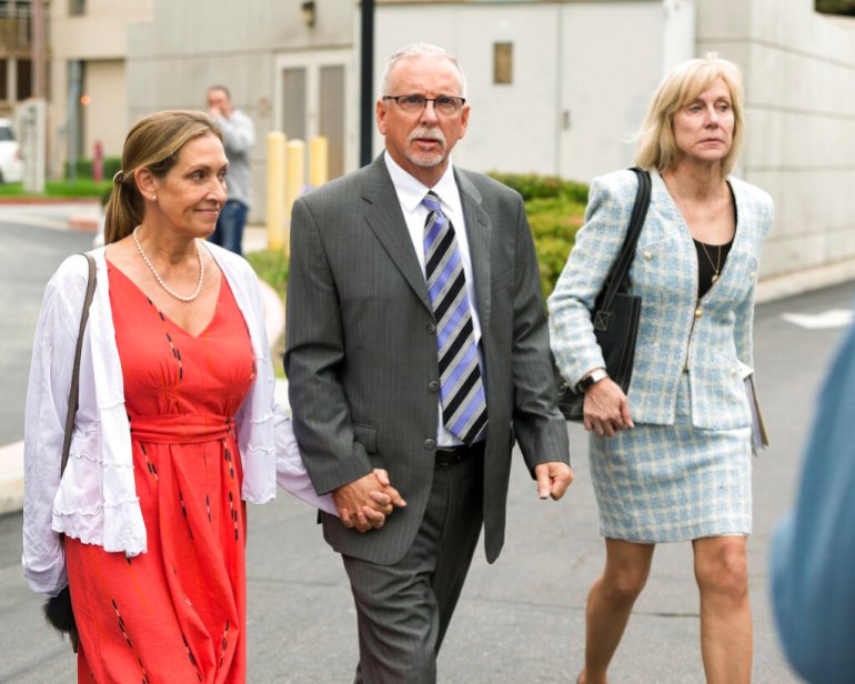 Former UCLA gynecologist Dr.  James Heaps, center, with his wife Deborah, left, and defense attorney Tracy Green leave Los Angeles Superior Court.