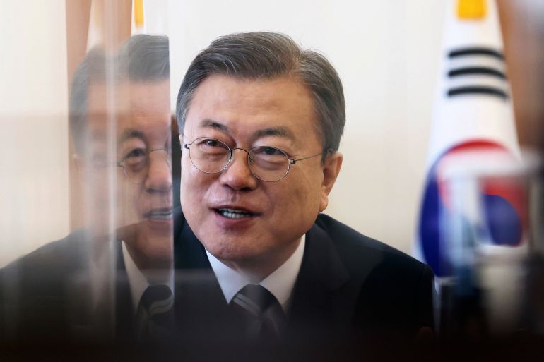 South Korean President Moon Jae-in, wearing a dark suit with white shirt and tie, is pictured at the presidential Blue House in Seoul, against a backdrop of South Korean flags