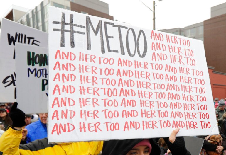 A marcher carries a sign with the popular Twitter hashtag #MeToo used by people speaking out against sexual harassment as she takes part in a Women's March in Seattle.