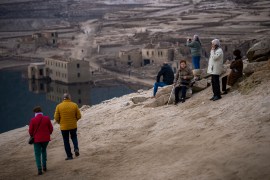 Visitors look at the old village of Aceredo emerged due to drought at the Lindoso reservoir, in northwestern Spain