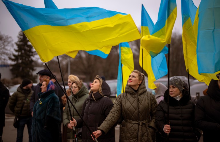 Women hold Ukrainian flags as they gather to celebrate a Day of Unity in Odessa, Ukraine