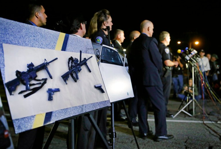 Police crime photos of assault rifles and handguns are displayed during a news conference near the site of a mass shooting in San Bernardino, California.