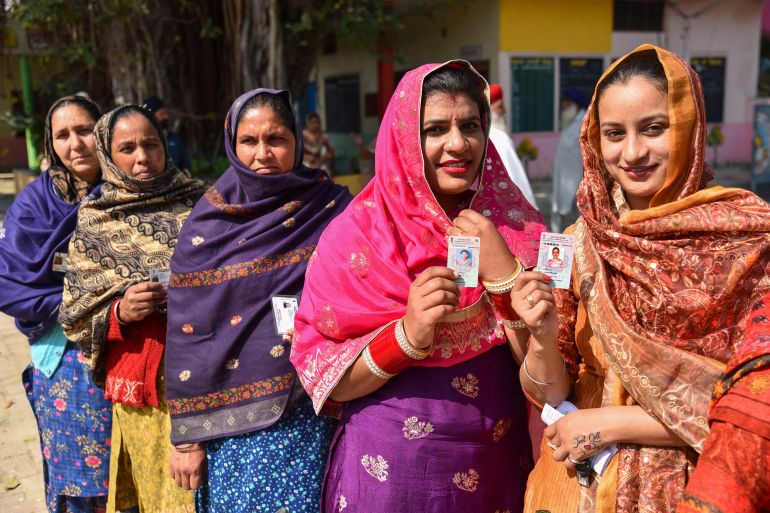 Village women display their voter identity cards as they arrive to cast their votes for the Punjab State Assembly elections