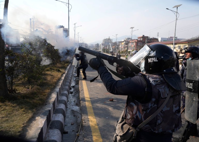 A Nepalese policeman fires tear gas at protesters in the capital Kathmandu