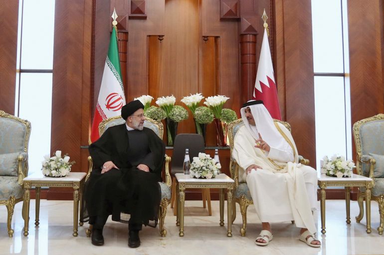 President Ebrahim Raisi, left, listens to Qatari Emir Tamim bin Hamad Al Thani, in Doha