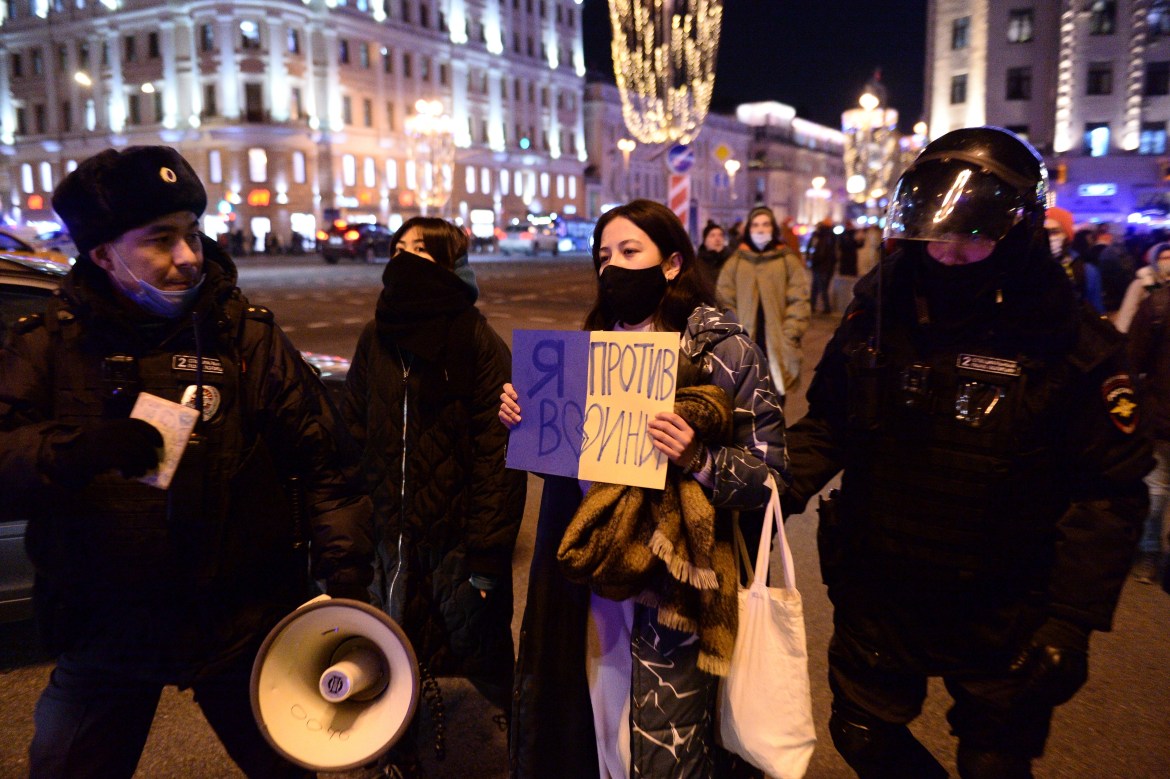 Police officers detain a demonstrator with a poster that reads: "I'm against the war", in Moscow