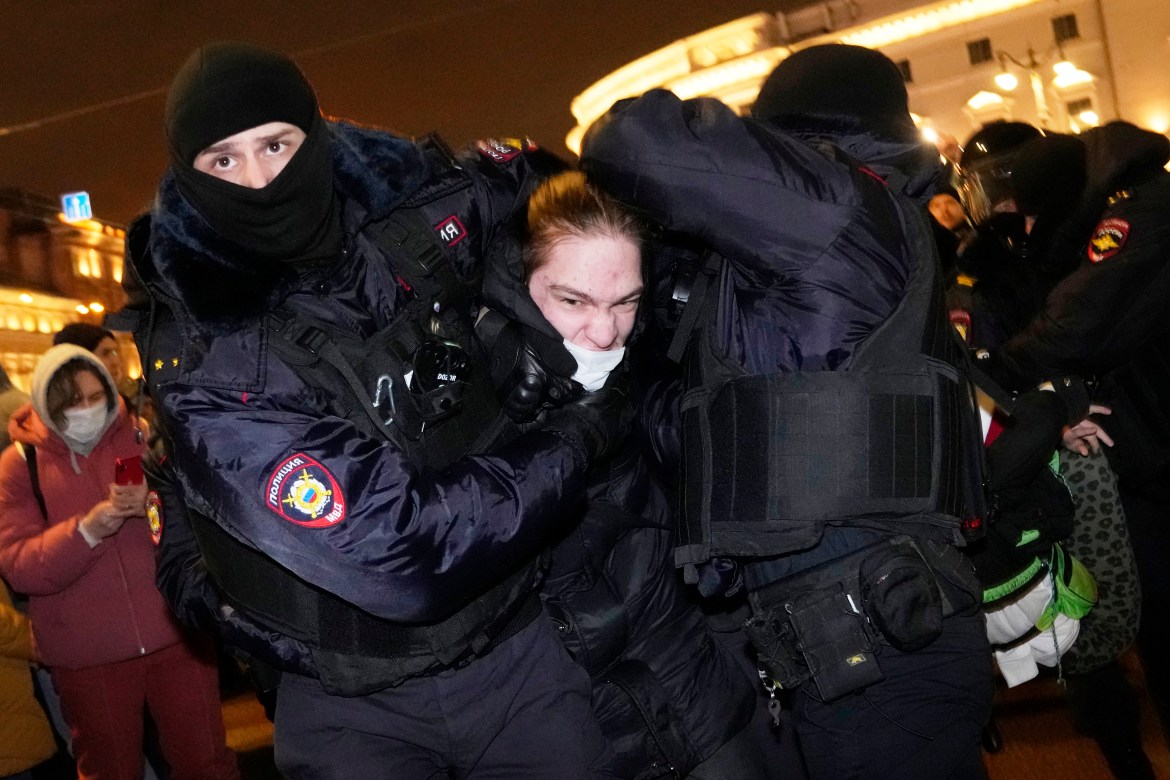 Police officers detain a demonstrator in St. Petersburg