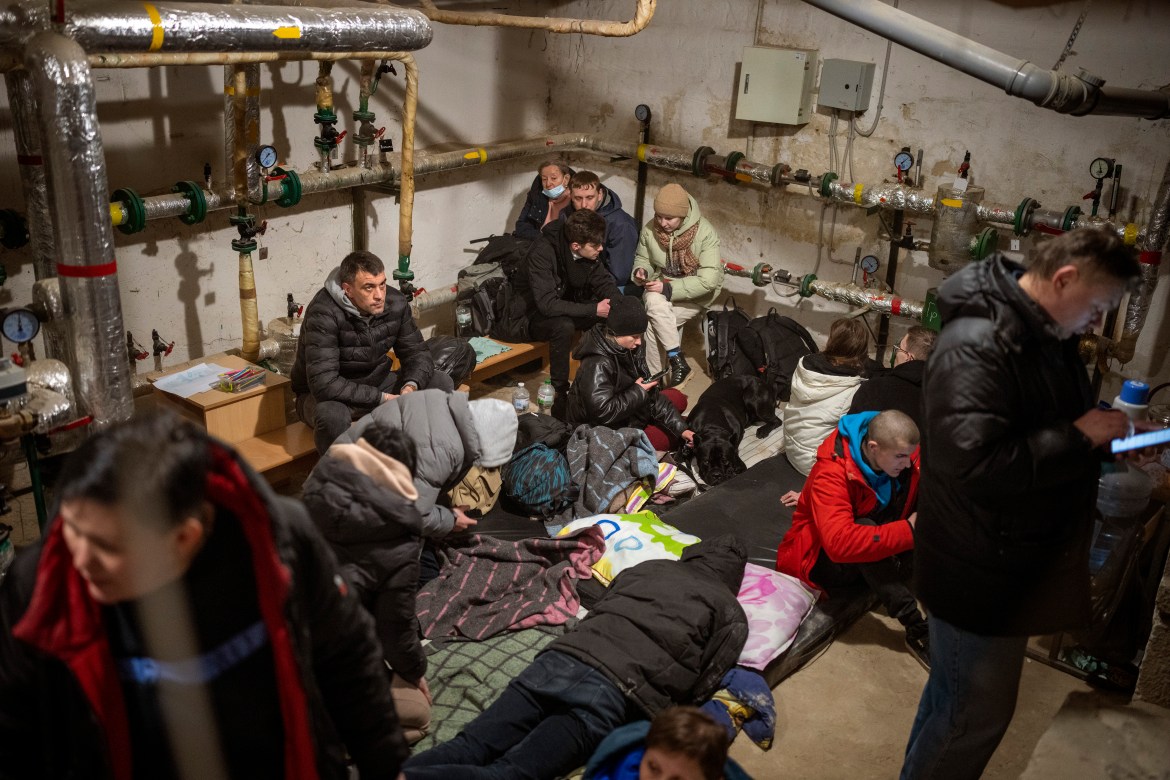 People take shelter at a building basement while the sirens sound announcing new attacks in the city of Kyiv