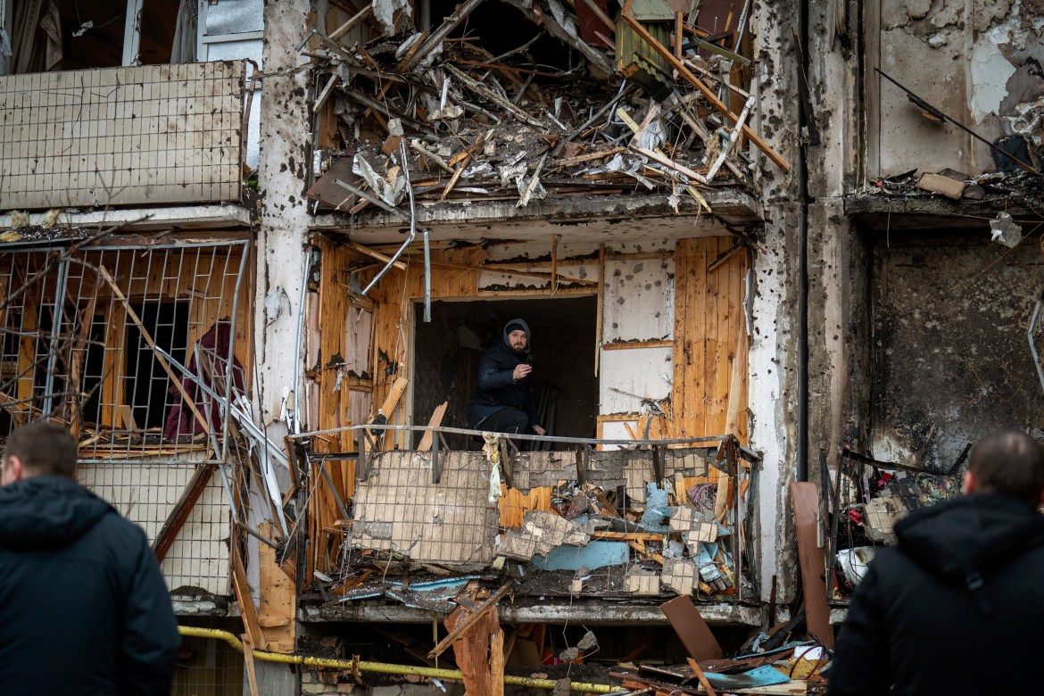 A man inspects the damage at a building following a rocket attack on the city of Kyiv,
