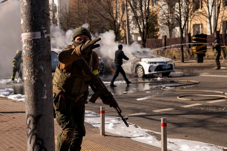 Ukrainian soldiers are seen taking positions outside a military facility in Kyiv