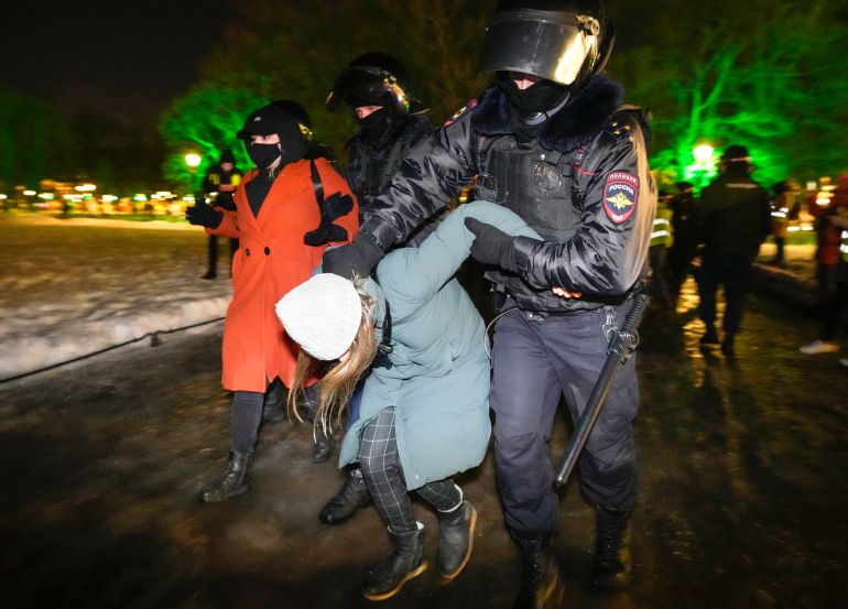 Police arrest a woman protester in Russia