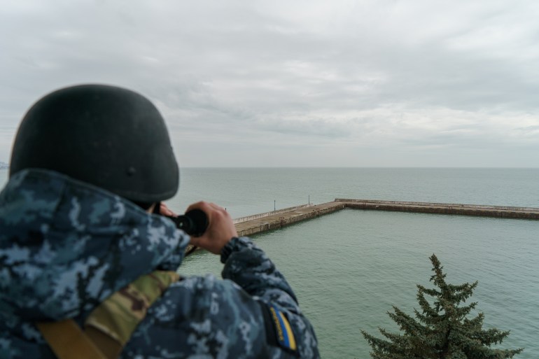 A coast guard looking through a binocular for possible Russian vessels on the Azov sea. Mariupol,Ukraine 2022.
