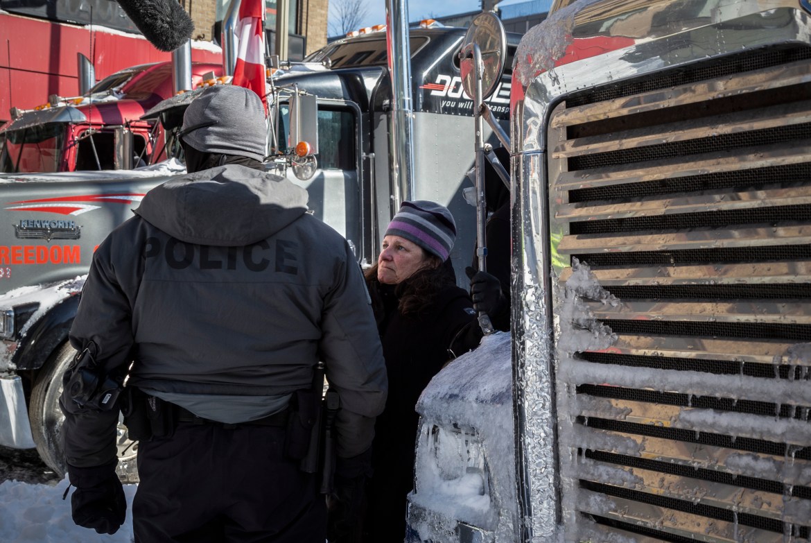 A protester stands between big rigs in Ottawa