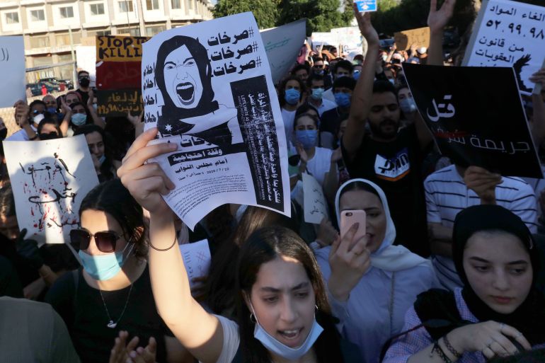 Women hold placards denouncing violence against women in Amman, Jordan