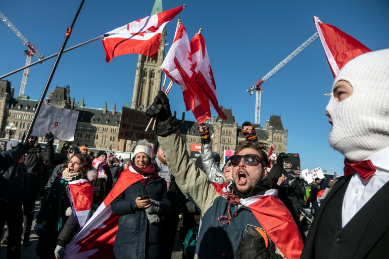 Protesters sing “O Canada” in front of the Partliament building.