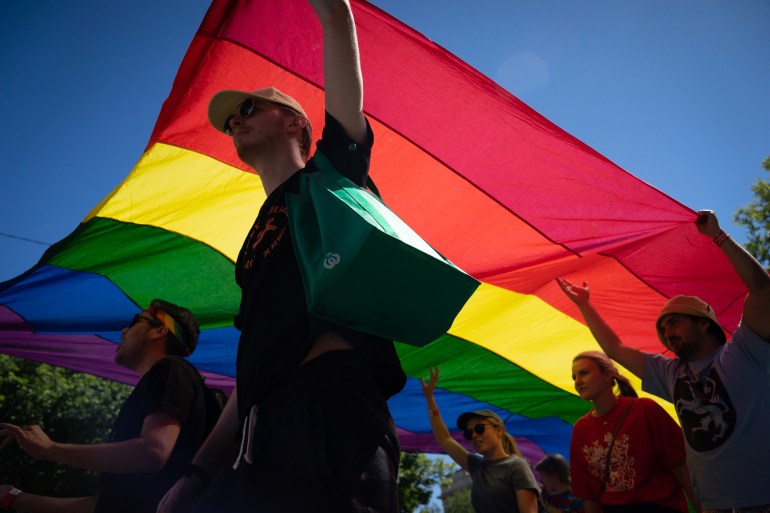 A man walks beneath the rainbow Pride flag in Melbourne