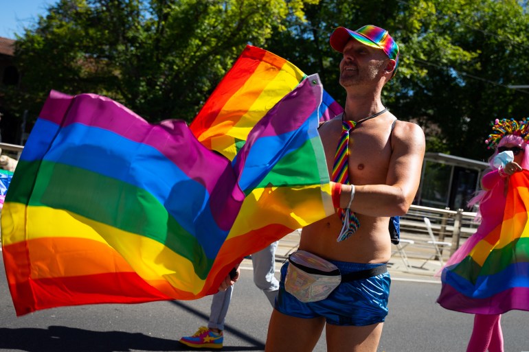 a bare chested man walks withe rainbow flag at the Pride March in Melbourne earlier this momth