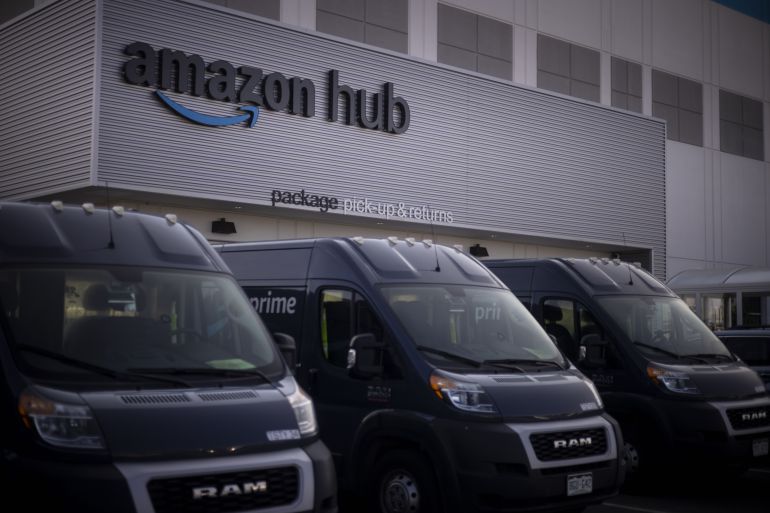 Delivery vans parked outside the package pick-up and returns area of an Amazon fulfillment center in Denver, Colorado, US