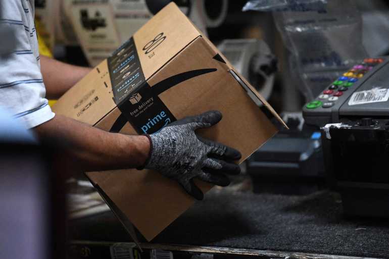 A worker assembles a box for delivery at the Amazon fulfillment center